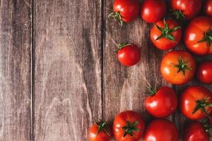 tomater på gammal trä- tabell, färsk röd tomat grönsaker platt lägga med kopia Plats foto