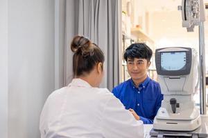 selektiv fokus på skärm av optometri Utrustning. medan optiker använder sig av subjektiv refraktion till undersöka öga visuell systemet av ung män patient med professionell maskin innan tillverkad glasögon. foto