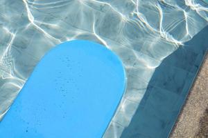 blå kickboard flytande på simning slå samman vatten yta. foto