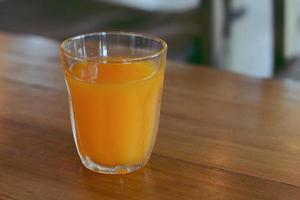 glas av orange juice på trä- tabell. foto