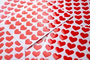 stänga upp röd hjärta klistermärke på vit papper foto