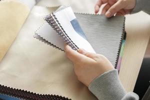 kvinna designer med tyg Färg prover välja textil- för gardiner foto