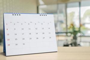 vit papper skrivbord kalender på trä tabell med suddig bokeh bakgrund utnämning och företag möte begrepp foto