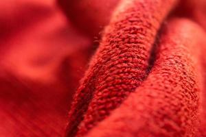närbild röd stickat ull- tyg textur bakgrund foto