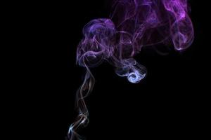 flerfärgad rök för aromaterapiavkoppling på svart bakgrund, vackra virvlade rökpuffar foto