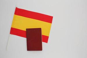 nationell pass och flagga av Spanien på vit bakgrund. invandring, flykting, förändra av medborgarskap, politisk tillflykt, bostad, europeisk union begrepp. resa, recieving visum och turism aning foto