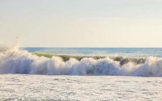 ytterst enorm stor surfare vågor på strand puerto escondido Mexiko. foto