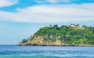 skön surfare vågor stenar klippor på strand puerto escondido Mexiko. foto