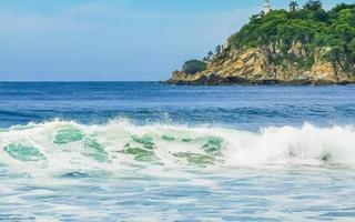 skön surfare vågor stenar klippor på strand puerto escondido Mexiko. foto