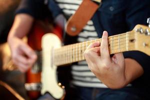 en musiker spelar ett elektrisk gitarr på en konsert. foto