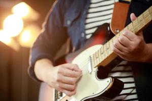 en musiker spelar ett elektrisk gitarr på en konsert. foto