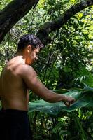 ung man, håller på med yoga eller reiki, i de skog mycket grön vegetation, i Mexiko, guadalajara, bosque colomos, latinamerikan, foto