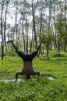 latin amerikan man håller på med yoga hållning, yoga hållning, bi bakåt prsthatah brahmara, skog foto