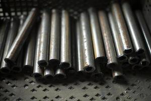 rör tillverkad av metall är skära. massor av stål rör. ämnen i de verkstad. foto