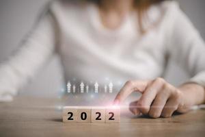 Start till de år 2022, hand rörande trä kub för 2022 år. kreativ bakgrund för de ny år. Lycklig ny år begrepp. foto