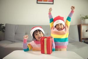 glad jul Lycklig syskon flickor med en gåva på Hem foto