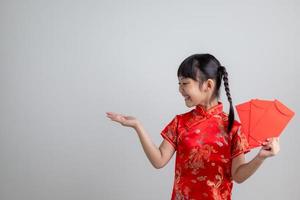 Lycklig kinesisk ny år. leende asiatisk liten flickor innehav röd kuvert foto