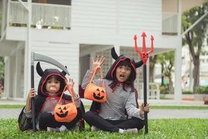 Lycklig halloween. syskon flicka i kostymer och med pumpor i de Hem foto