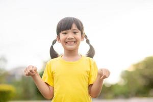 Lycklig liten asiatisk flicka barn som visar främre tänder med stor leende och skrattande friska Lycklig rolig leende ansikte ung förtjusande härlig kvinna kid.glad porträtt av asiatisk elementärt skola studerande. foto