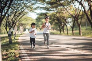 två asiatisk liten flickor har roligt och löpning tillsammans i de parkera i årgång Färg tona foto