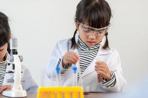 utbildning, vetenskap, kemi och barn begrepp - barn eller studenter med testa rör framställning experimentera på skola laboratorium foto