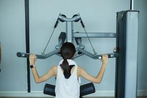 ung kondition flicka Kör övning med träningsmaskin i Gym foto