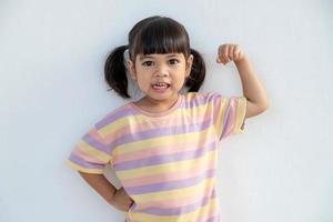 glada asiatiska barn visar hennes starka händer foto