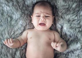 bebis flicka gråt i en slå in foto