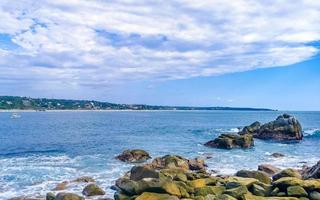 skön surfare vågor stenar klippor på strand puerto escondido Mexiko. foto