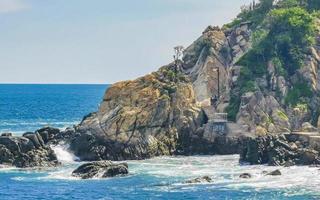 skön surfare vågor stenar klippor på strand puerto escondido Mexiko. foto