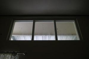 tre glas fönster lådor på de topp av de hus foto