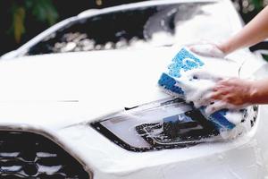 detta man är tvättning de bil och rengöring de bil. foto