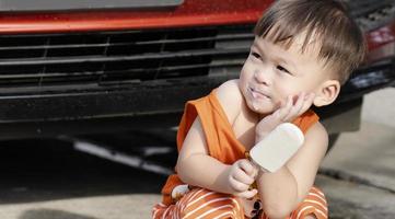 barn äta is grädde lyckligt. söt liten asiatisk pojke äter is grädde foto