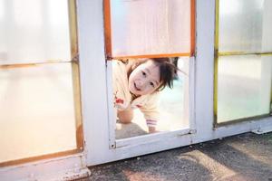 söt ung asiatisk flicka spelar lyckligt och utseende genom de färgrik glas fönster på sommar helgen. ljusstyrka av asiatisk barn. de begrepp av inlärning saker runt om är Lycklig. foto