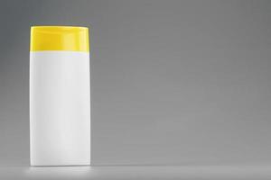 vit plast flaska med gul keps med schampo gel på grå bakgrund foto