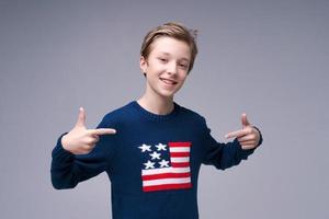 glad avslappnad nöjd stilig ung man står i blå tröja med usa foto