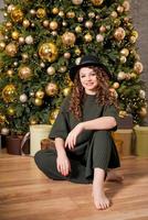 caucasian ung kvinna Sammanträde på golv nära jul träd på Hem i levande foto