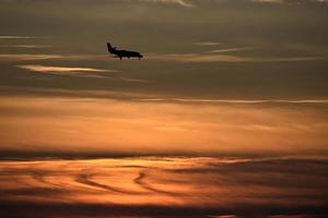 silhuett av ett flygplan vid solnedgången foto