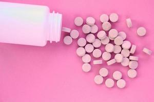 tabletter, kapsel, piller och vit plast packa på rosa bakgrund. vitamin recept tillägg, läkemedel, farmaceutisk medicin hälsa terapi aning. självmord missbruk överdos begrepp. doping steroid foto
