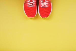 sporter sneakers, rosa på en gul bakgrund med fri Plats. foto