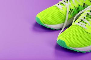 grön löpning skor på en lila bakgrund. foto