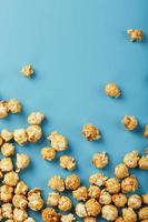 popcorn är spridd på en blå bakgrund, i de form av en ram. foto