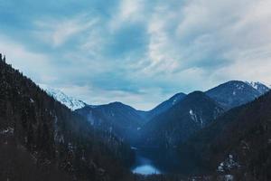 vinter- sjö ritsa i abkhazia med bergen i de snö i de bakgrund, sent kväll. foto