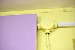 montering de elektrisk kabel- på de vägg i skydd på en färgad vägg. elektrisk trådar är skyddade inomhus. foto