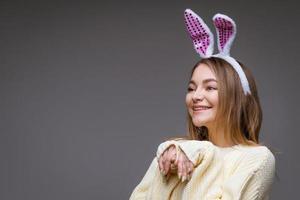 porträtt av en söt flicka med kanin öron på en grå bakgrund foto