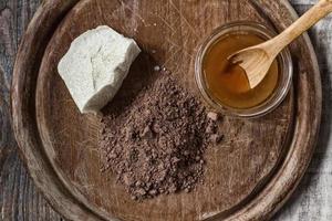 kakaosmör, kakaopulver och honung på grungeträbakgrund
