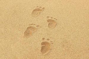 baby fotspår i sanden på en strand