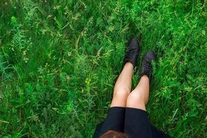 kvinna Sammanträde på grön gräs topp se foto