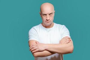 emotionell man i vit t-shirt med arg ansiktsbehandling uttryck på bakgrund, isolering foto