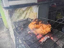 kyckling bröst insvept i Krispig mjöl med utsökt kryddad kryddor grillad på varm träkol.typiskt grillad kyckling mat från indonesien foto